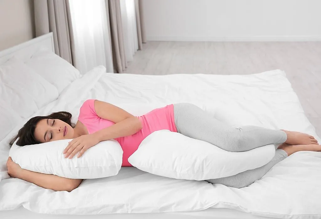 Woman sleeps with a pillow between her knees