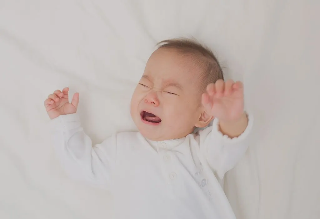 A baby crying on being put down on the bed