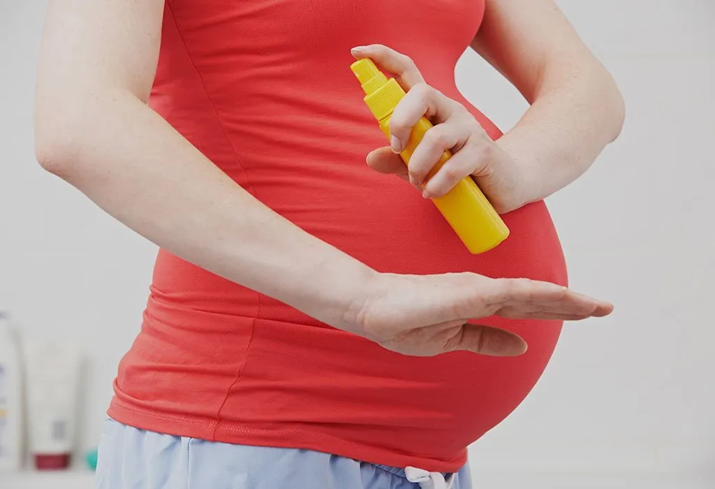 A pregnant woman using a mosquito repellant