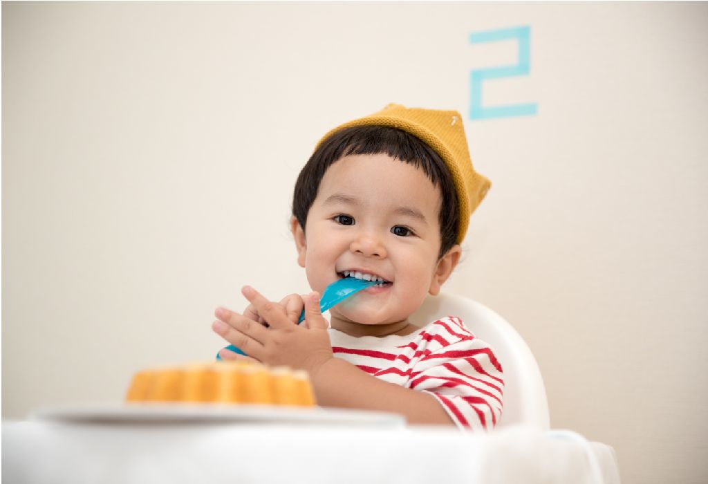 toddler eating with utensils