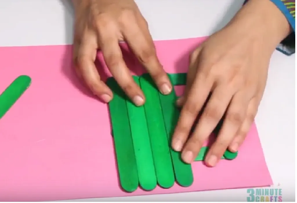 Place the four large popsicle sticks across these sticks towards the bottom.