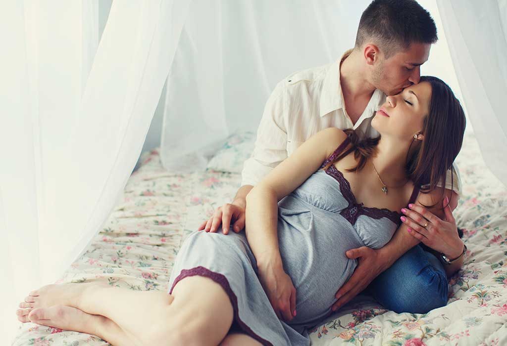 A pregnant wife and husband in bed