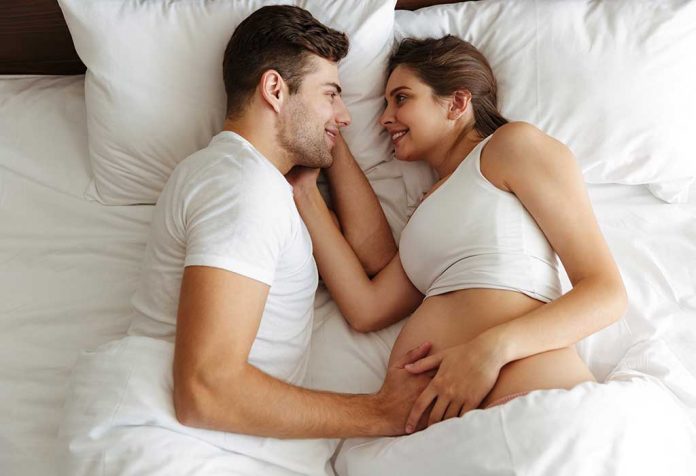 A pregnant wife and husband on bed