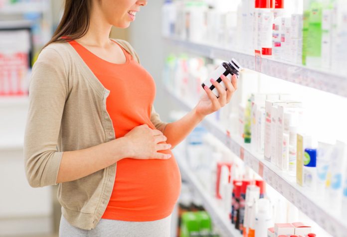 A pregnant woman buying medicines at a pharmacy