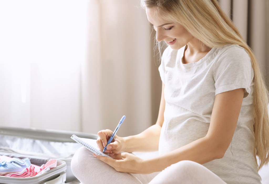 Pregnant woman listing down essentials & packing bag