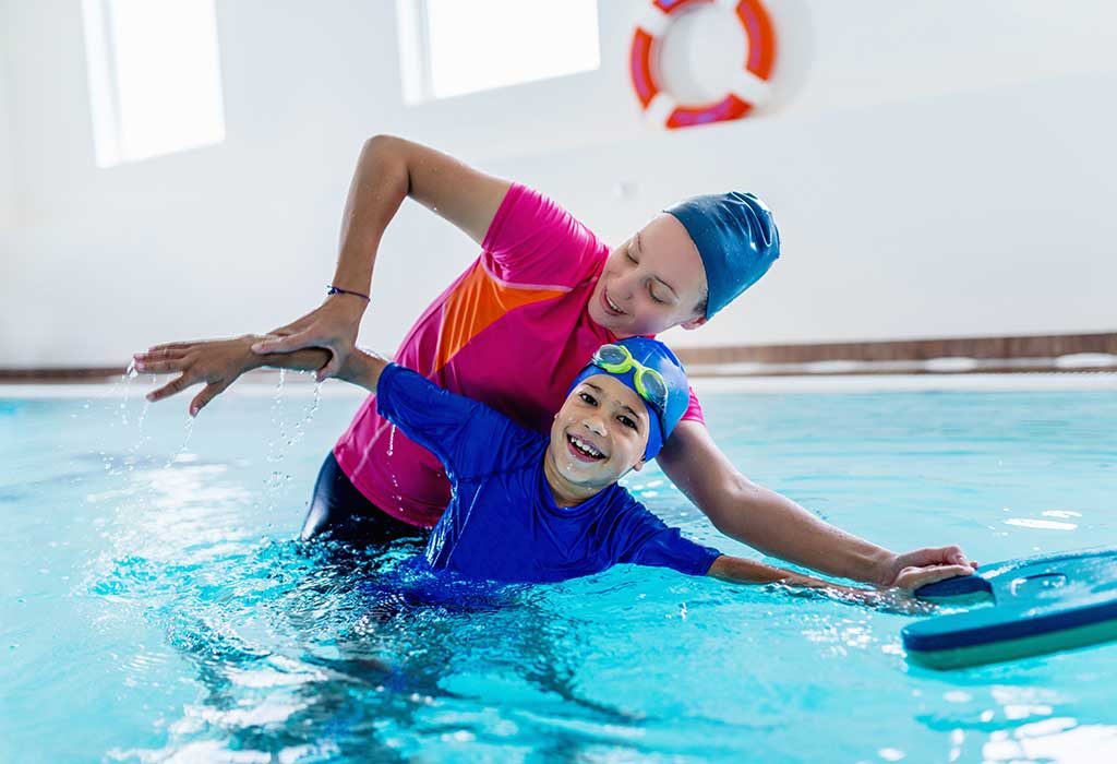 An  instructor teaching swimming to a boy