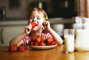 Menina comendo morango