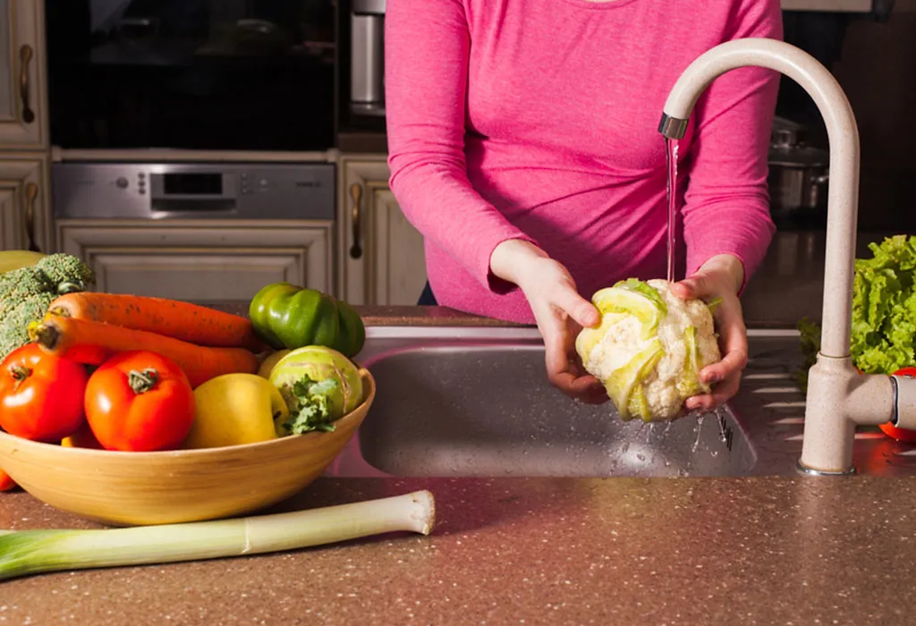 woman washing fruits and vegetables