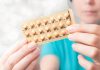 Woman holding birth control pills