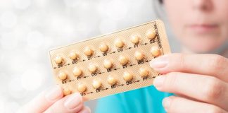 Woman holding birth control pills