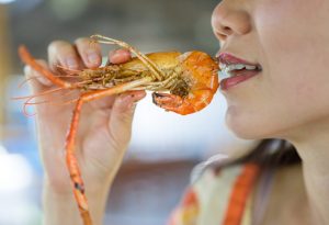 A woman eating shrimp