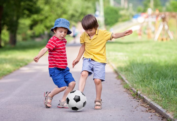 Two kids playing football