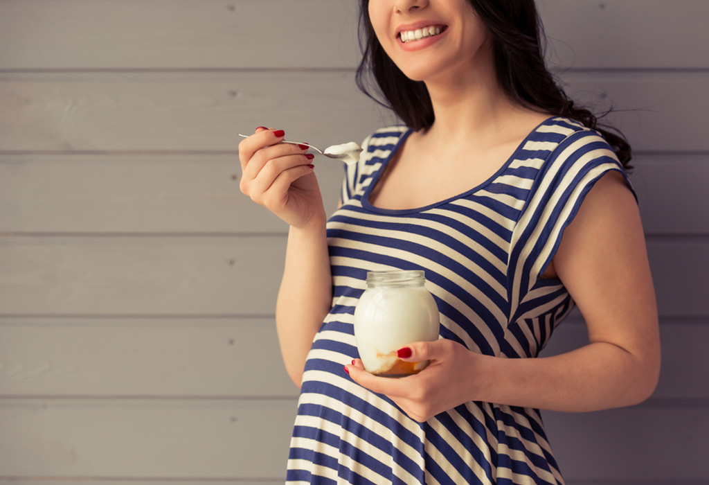 femeie însărcinată care mănâncă iaurt