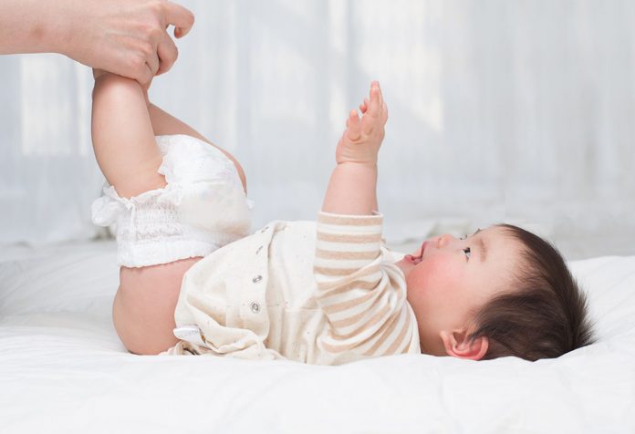 Mutter überprüft die Windel des Babys's diaper