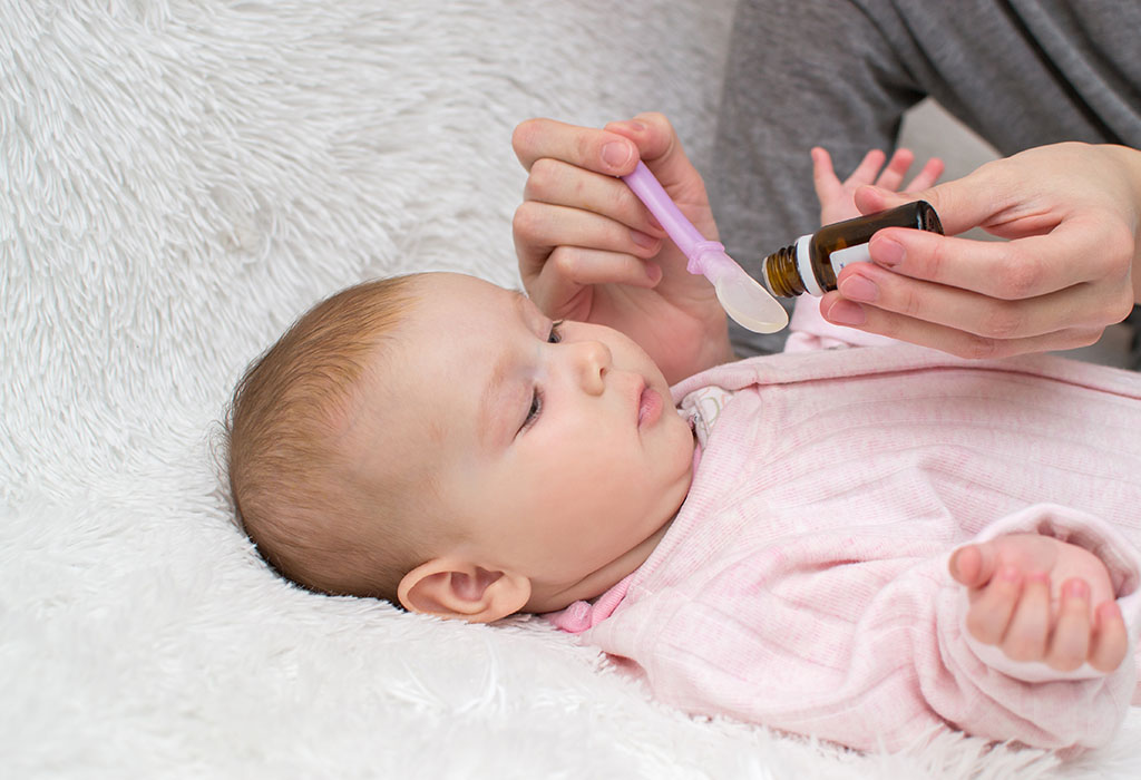 Mãe dando xarope para seu bebê