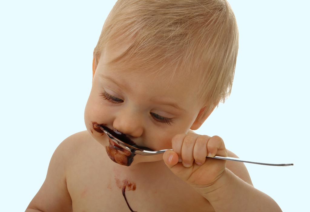 Baby eating chocolate sauce