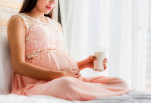 Una mujer embarazada con un vaso de leche