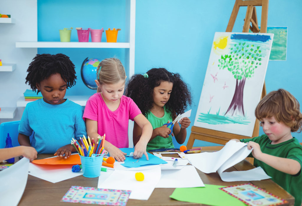  A group of children are sitting at a table doing arts and crafts.