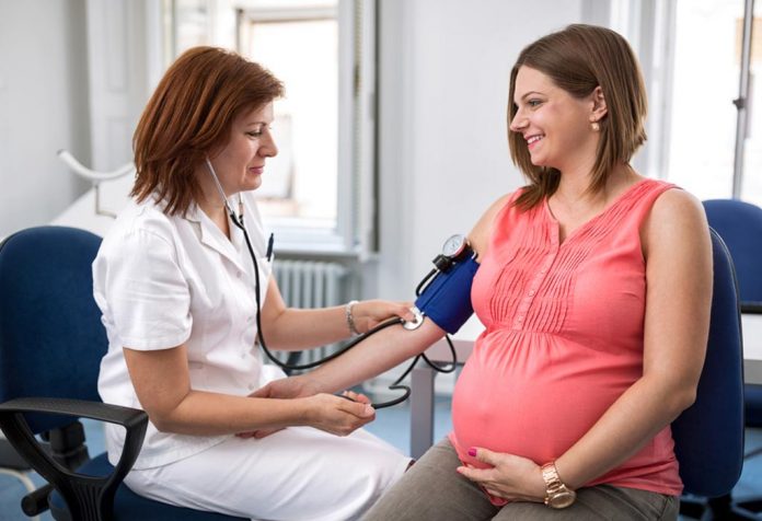 Checking blood pressure of a pregnant woman