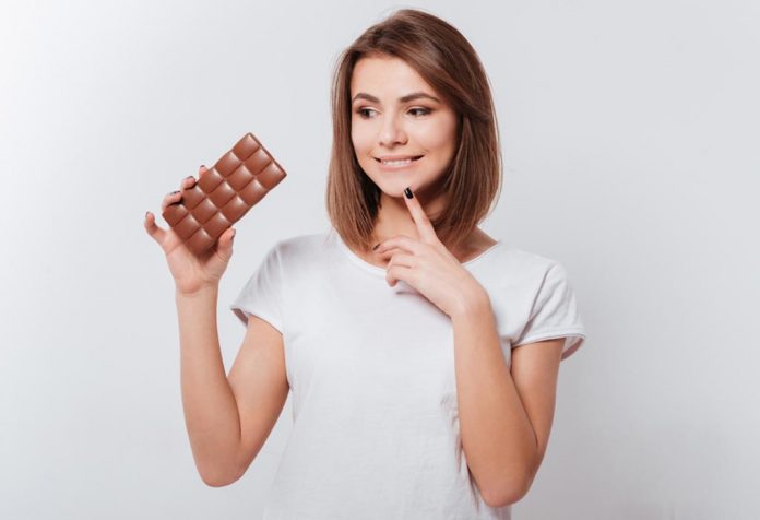 A woman thinking about eating chocolate