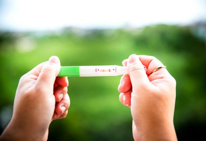 A woman holding a positive pregnancy test