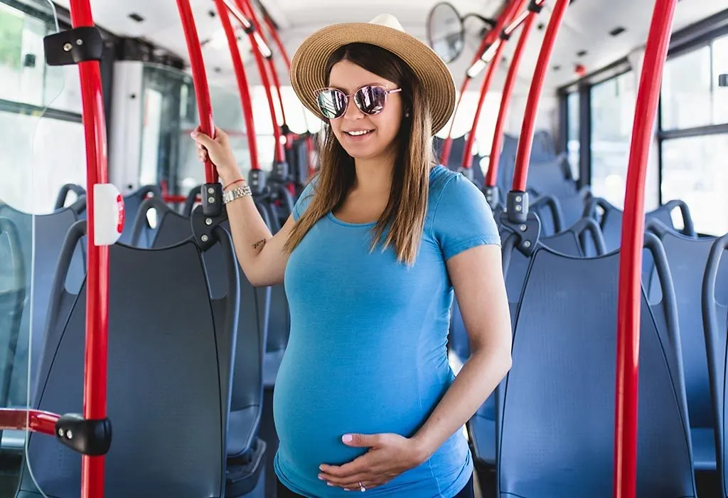 Pregnant woman standing in the bus
