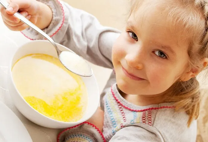 A little girl enjoying a bowl of soup