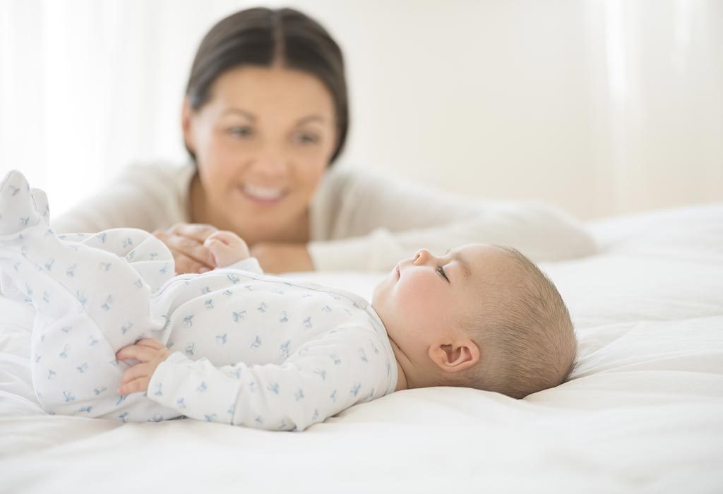 Mother checking on sleeping baby