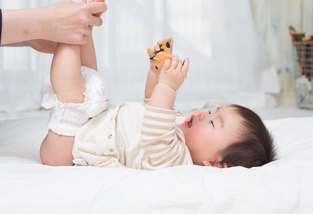 A mother checks her baby's diaper