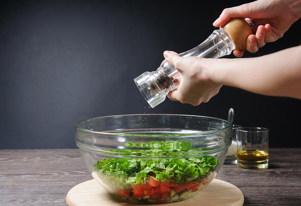 Adding pepper to salad