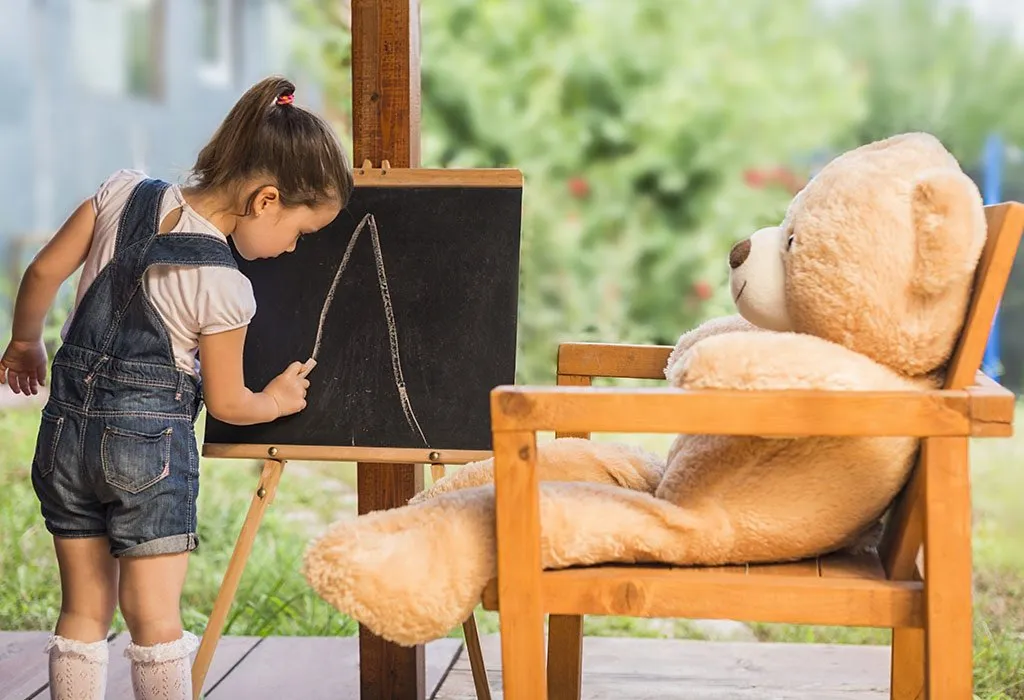 A girl writing an alphabet on a board
