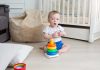 A baby assembling a coloured rings tower