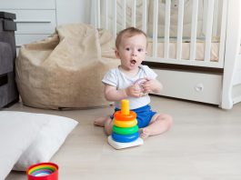 A baby assembling a coloured rings tower