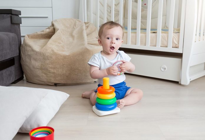 A baby assembling a coloured rings tower