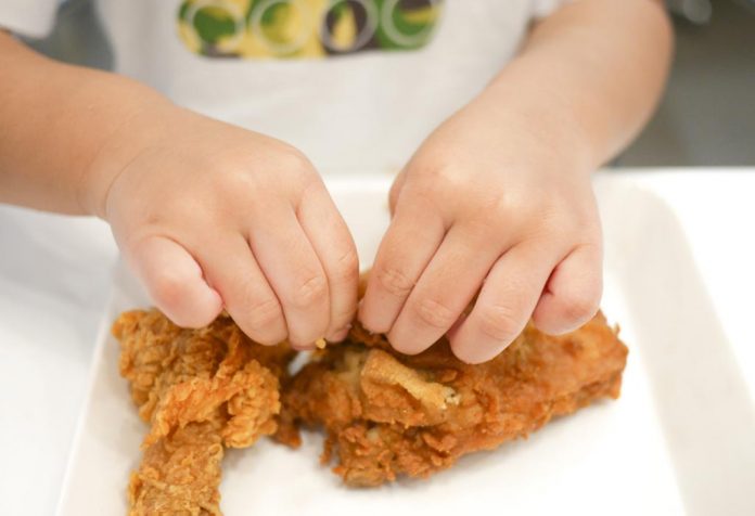 A child having deep fried chicken