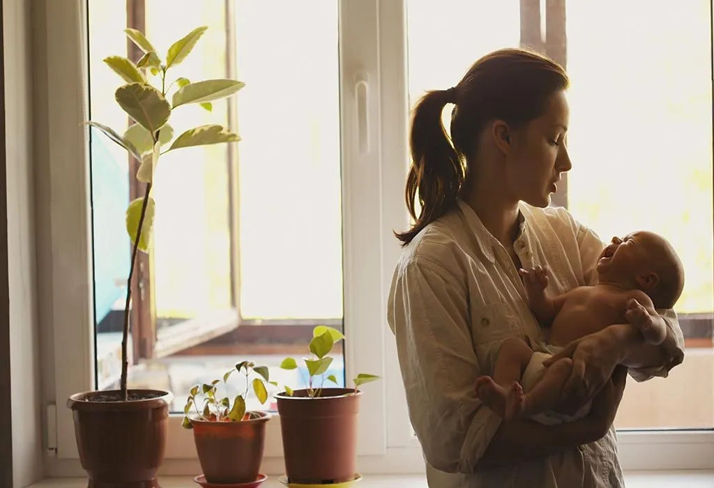 A mother swaddling her baby