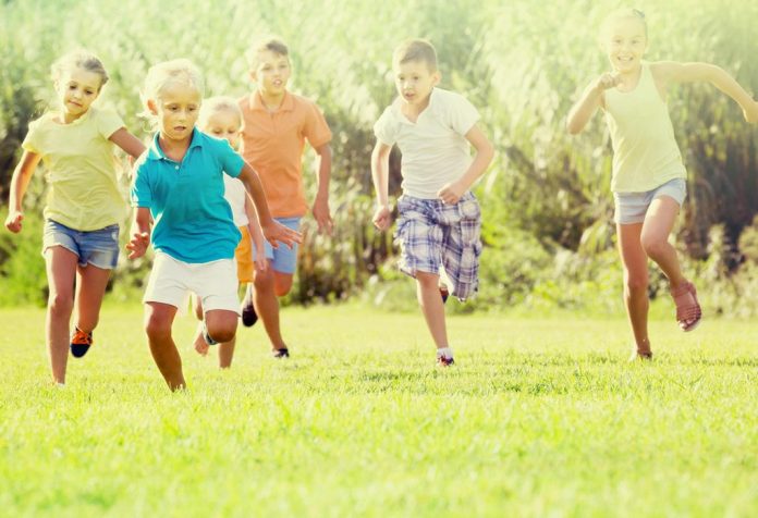 Kids running on the grass in summer