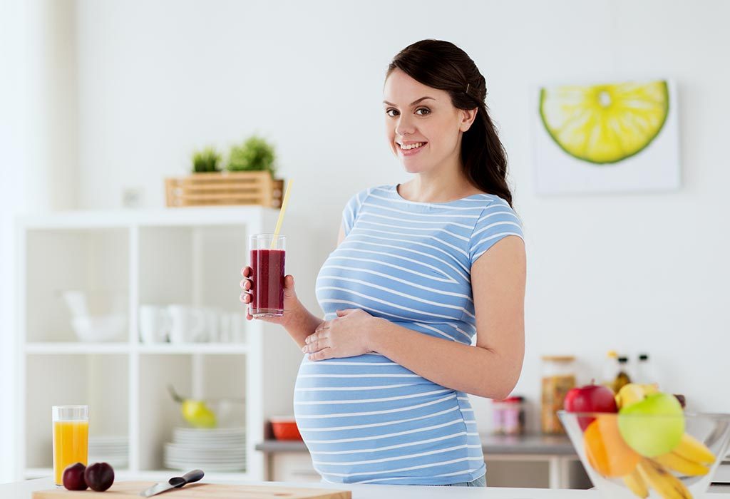 A pregnant woman drinking healthy juice