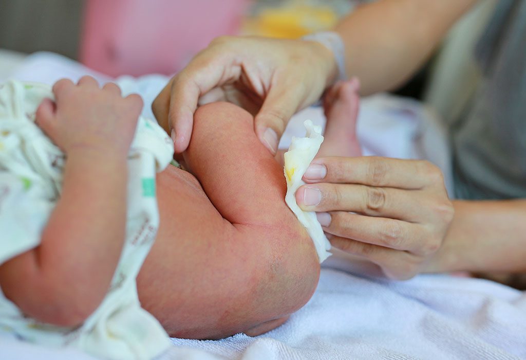 Mother wiping poop of her baby