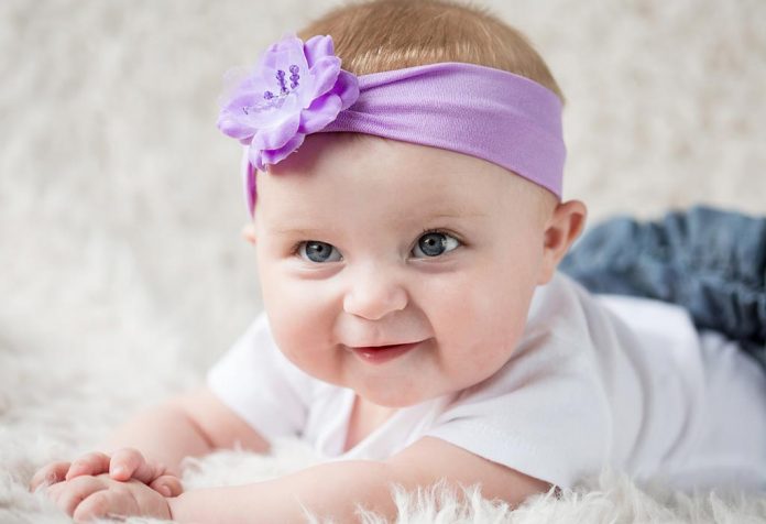 A baby girl wearing a purple hairband