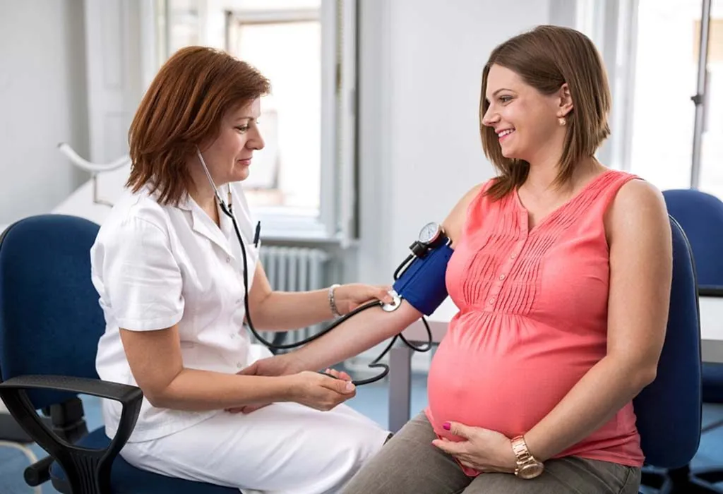 A doctor checks the blood pressure of a pregnant woman