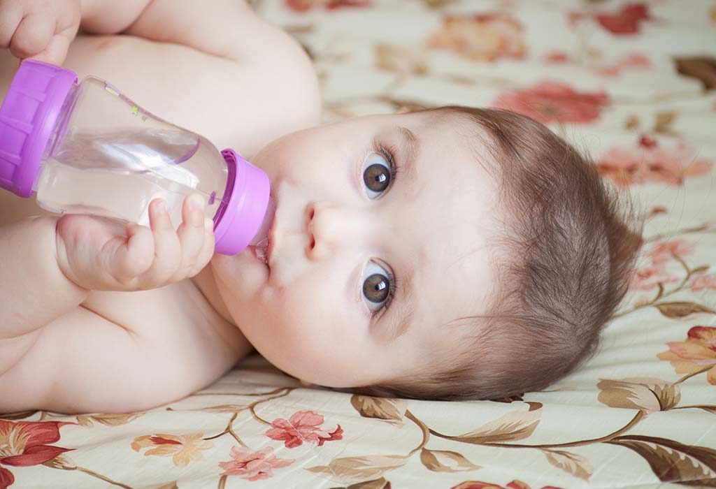 A baby drinking water through a bottle