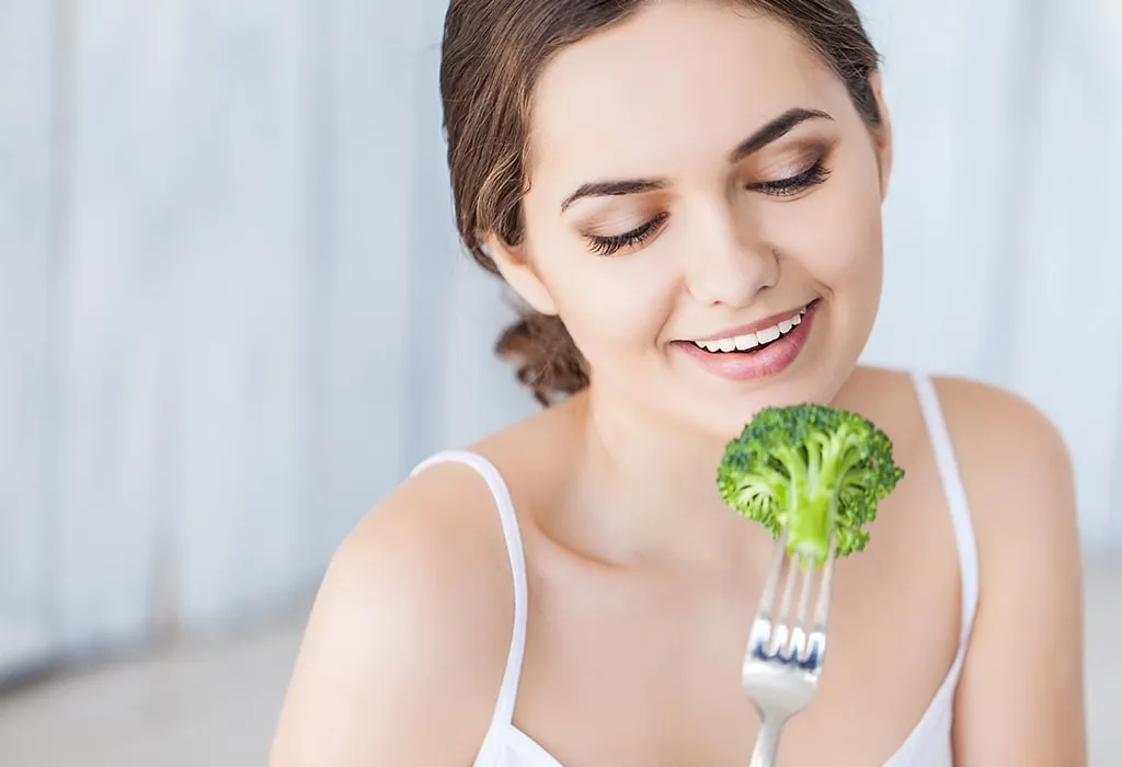 Pregnant lady eating broccoli Pregnant lady eating broccoli