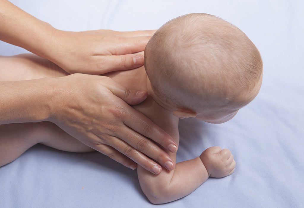 A mother massaging her baby