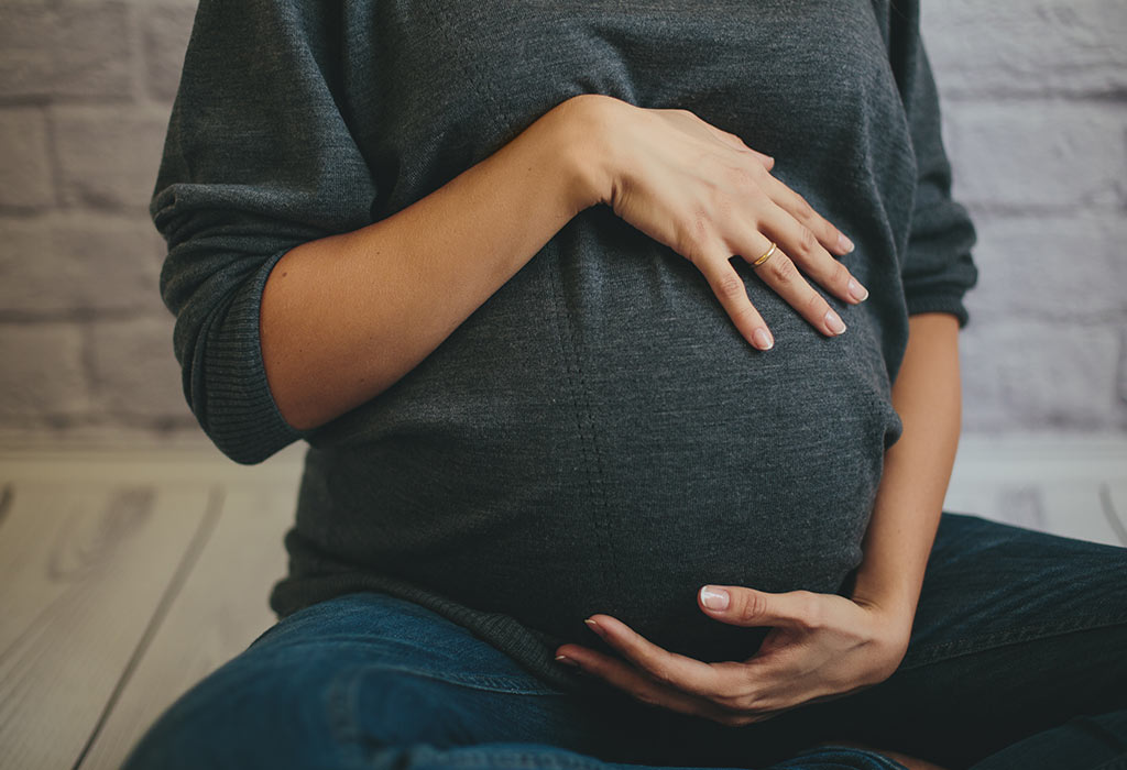 Uma mulher grávida segurando a barriga