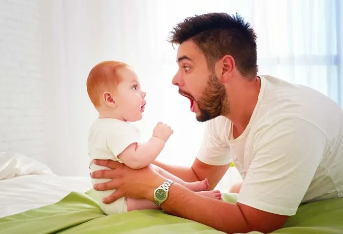A baby looking at his father