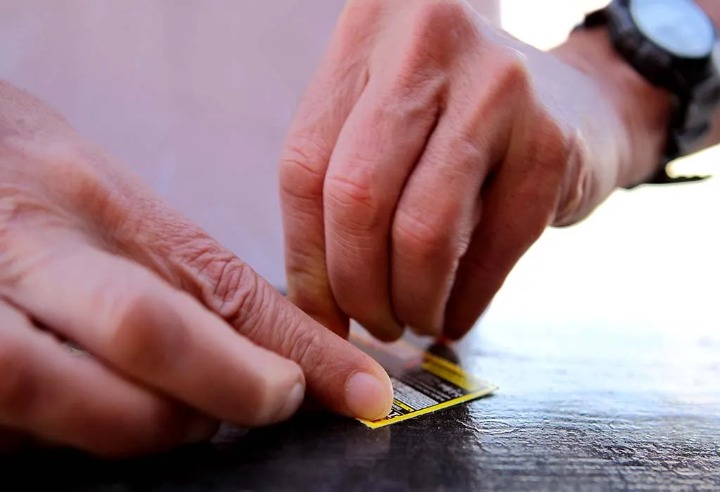 A father using a scratch card A father using a scratch card