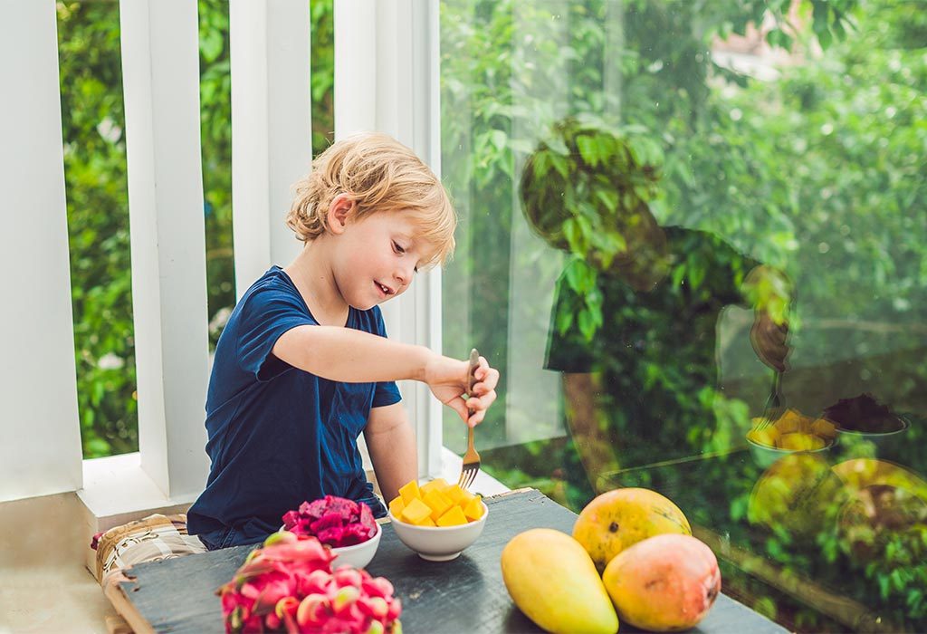 A kid eating mango