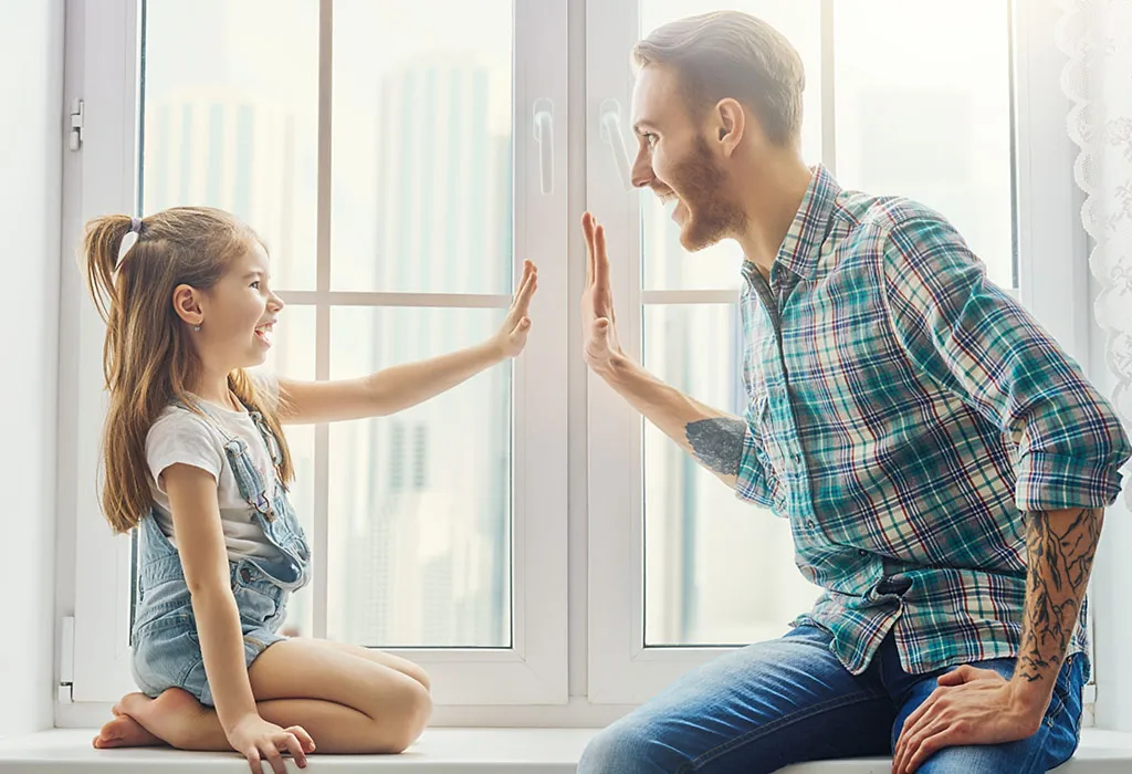 Father and daughter playing in window