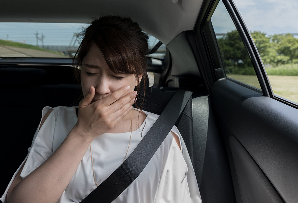 Pregnant woman feeling sick in car.